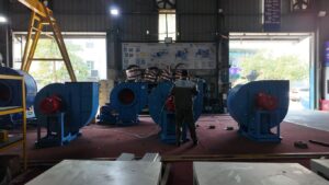 Industrial setting with large blue fans and equipment.