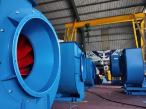 Industrial setting with large blue machinery and ventilation fans.