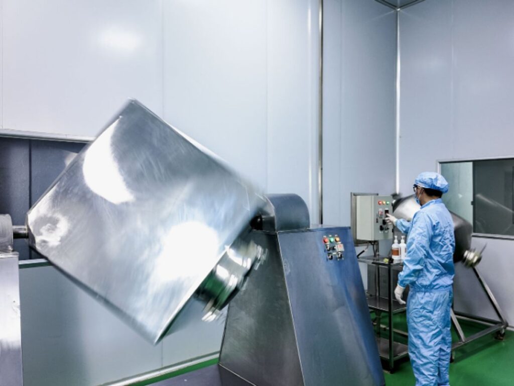 A person operates machinery in a clean industrial environment.