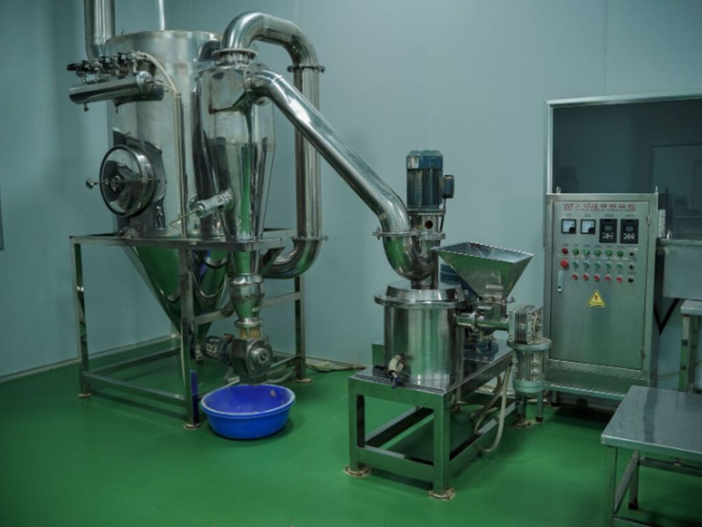 Industrial machinery setup in a clean, green-floored environment.