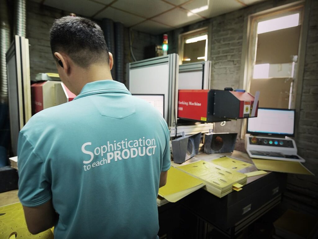 A person operates machinery in a workshop setting.